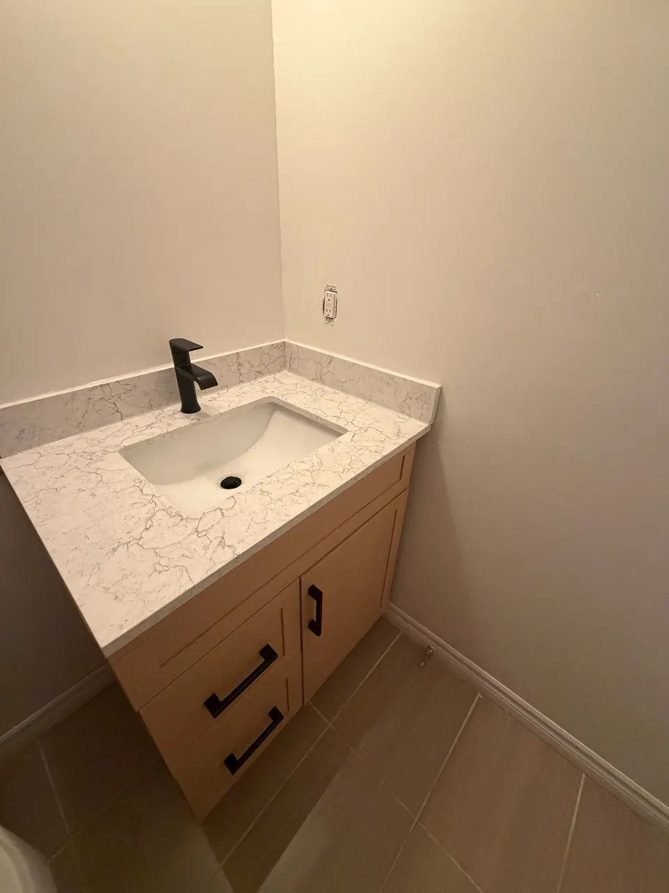 Compact vanity with quartz top and matte black faucet