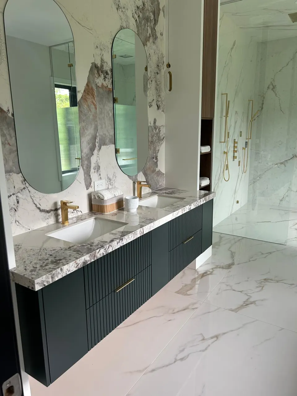 Double vanity with dark green fluted cabinet and arched mirrors