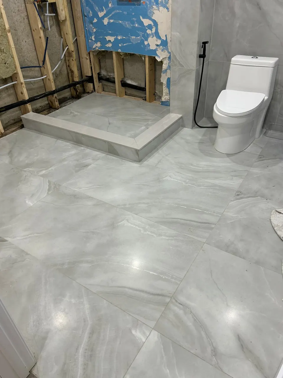 Shower curb and porcelain floor installed before the glass goes in