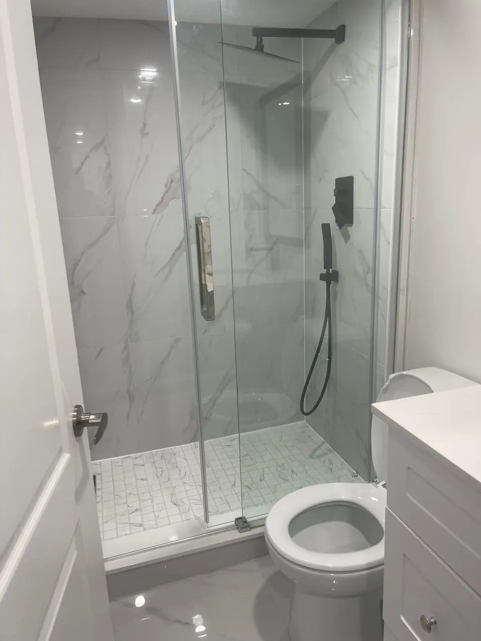 Glass shower with mosaic tile floor